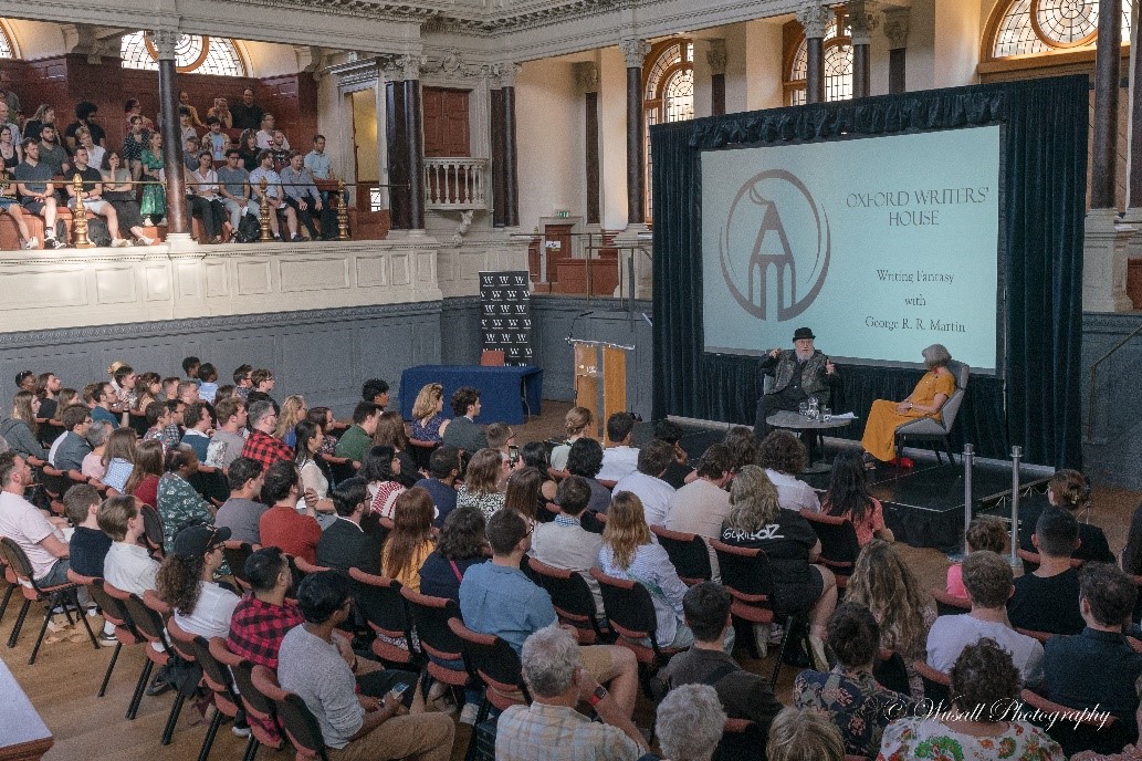 george r r martin speaking at the sheldonian theatre in front of audience