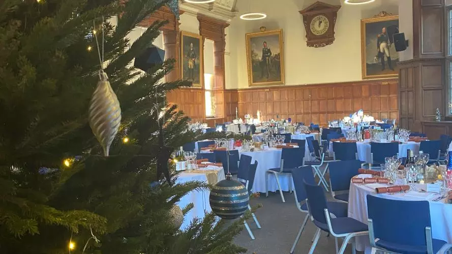 A festive party at the Examination Schools in Oxford, with a christmas tree in the foreground