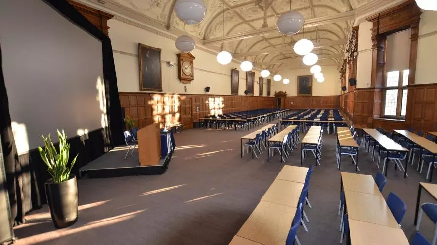 North Writing Schools set up for a lecture, with tables and chairs facing a large screen.