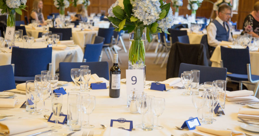 This is an image of a wedding reception table set-up with flowers at the Examination Schools