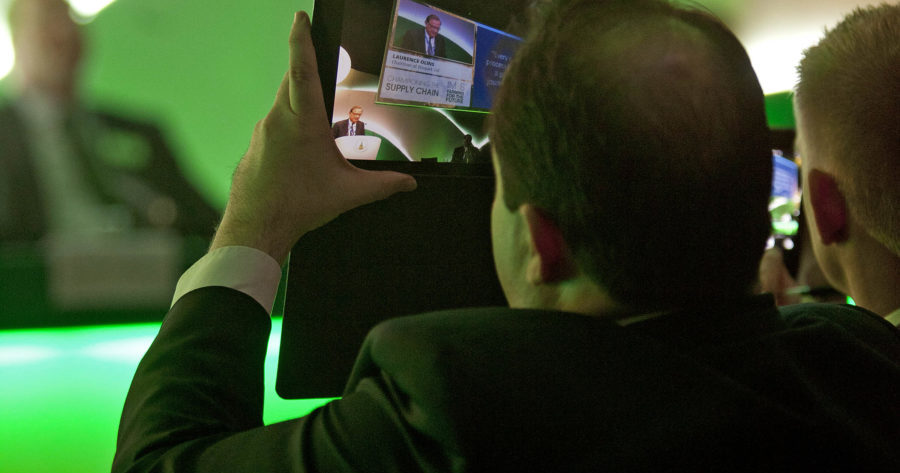 This is an image of someone taking a picture using an ipad at a conference held at the Examination Schools