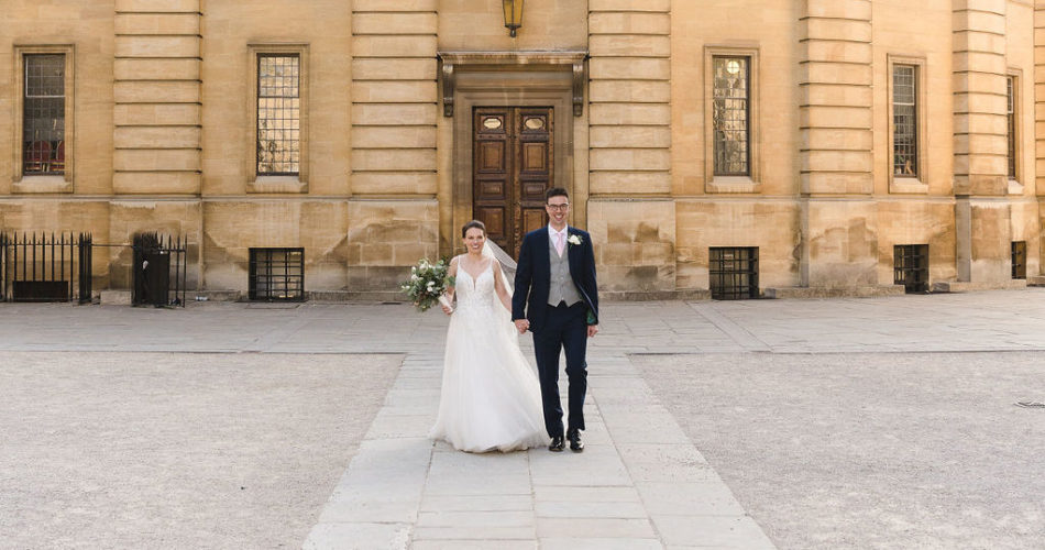 Bride and groom walking outside the Sheldonian Theatre