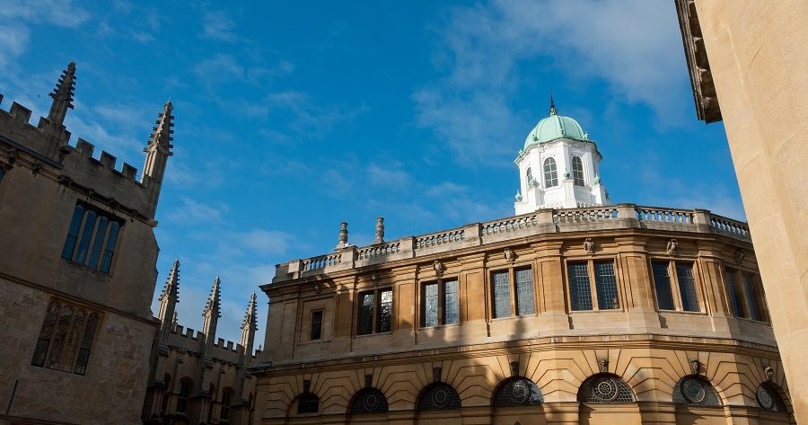 This image shows a side view of the Sheldonian Theatre against a beautiful blue sky